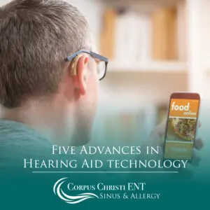 Man with hearing aid looking at phone